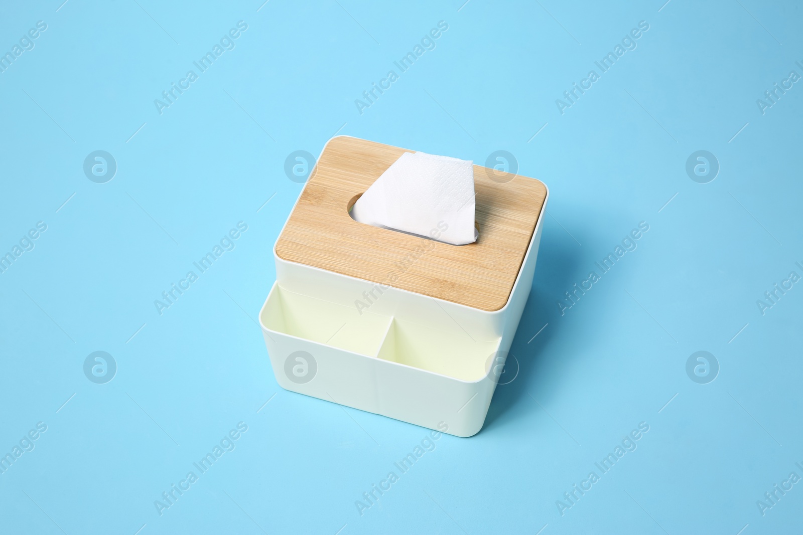 Photo of Holder with paper tissues on light blue background