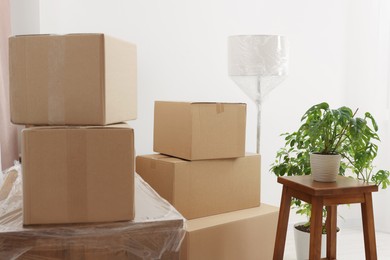 Photo of Lamp wrapped in stretch film, boxes and houseplant indoors