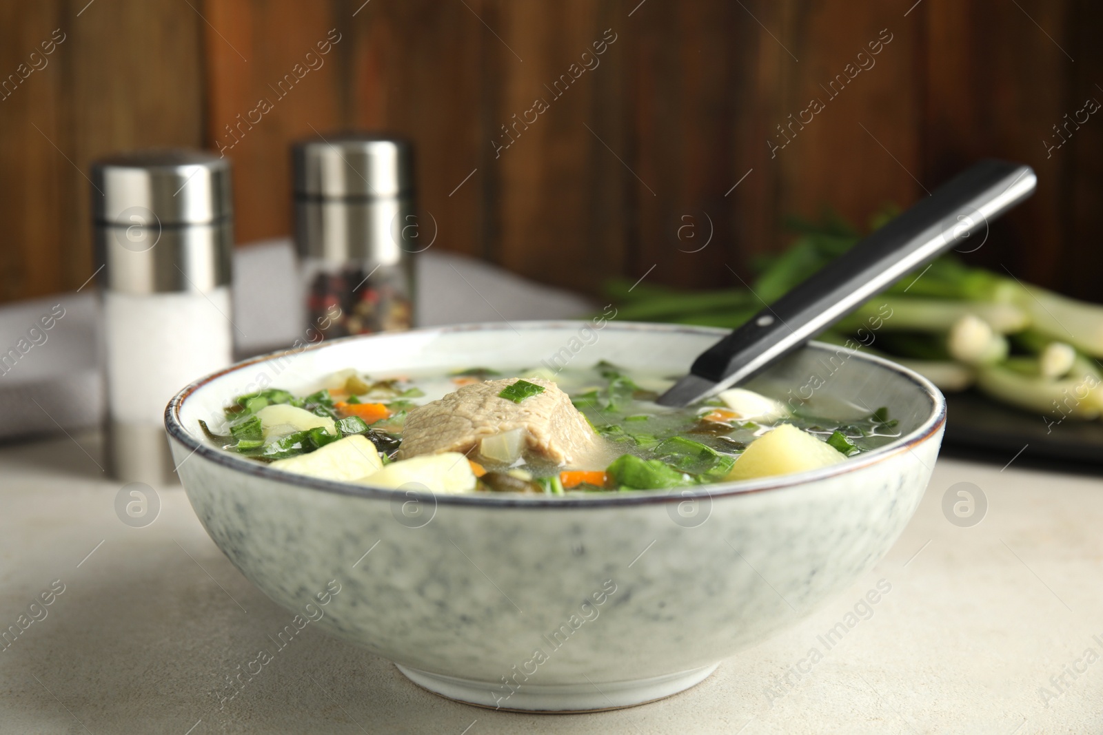 Photo of Delicious sorrel soup with meat served on table