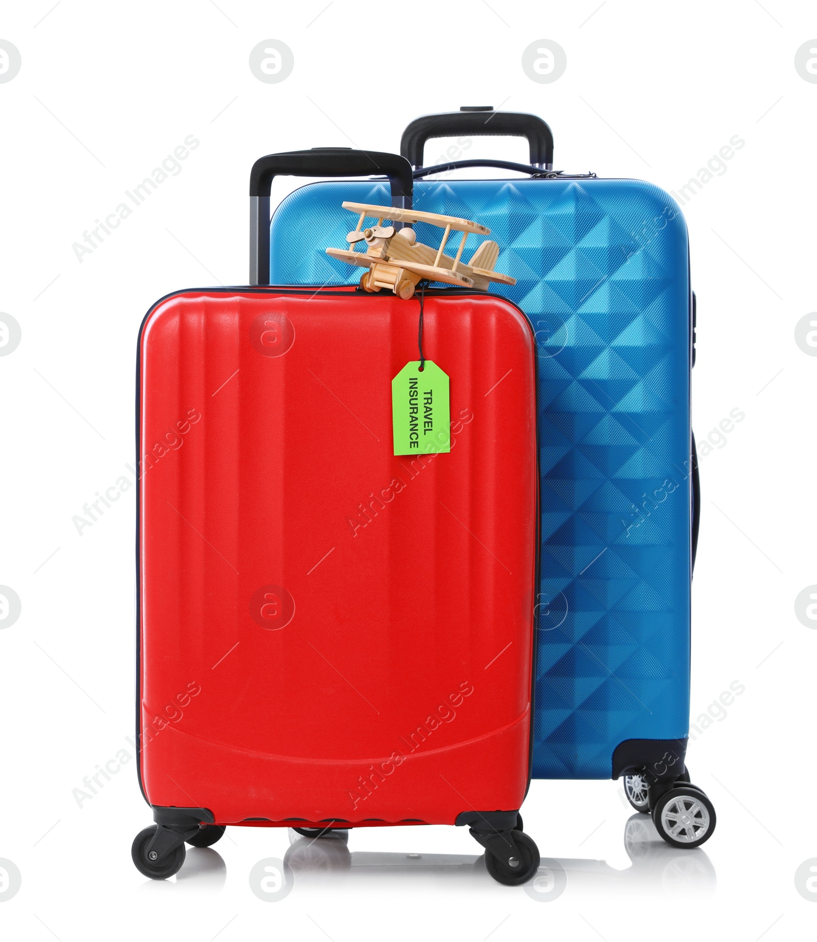 Photo of Red and blue suitcases with TRAVEL INSURANCE label on white background