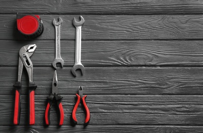 Flat lay composition with plumber's tools and space for text on wooden background