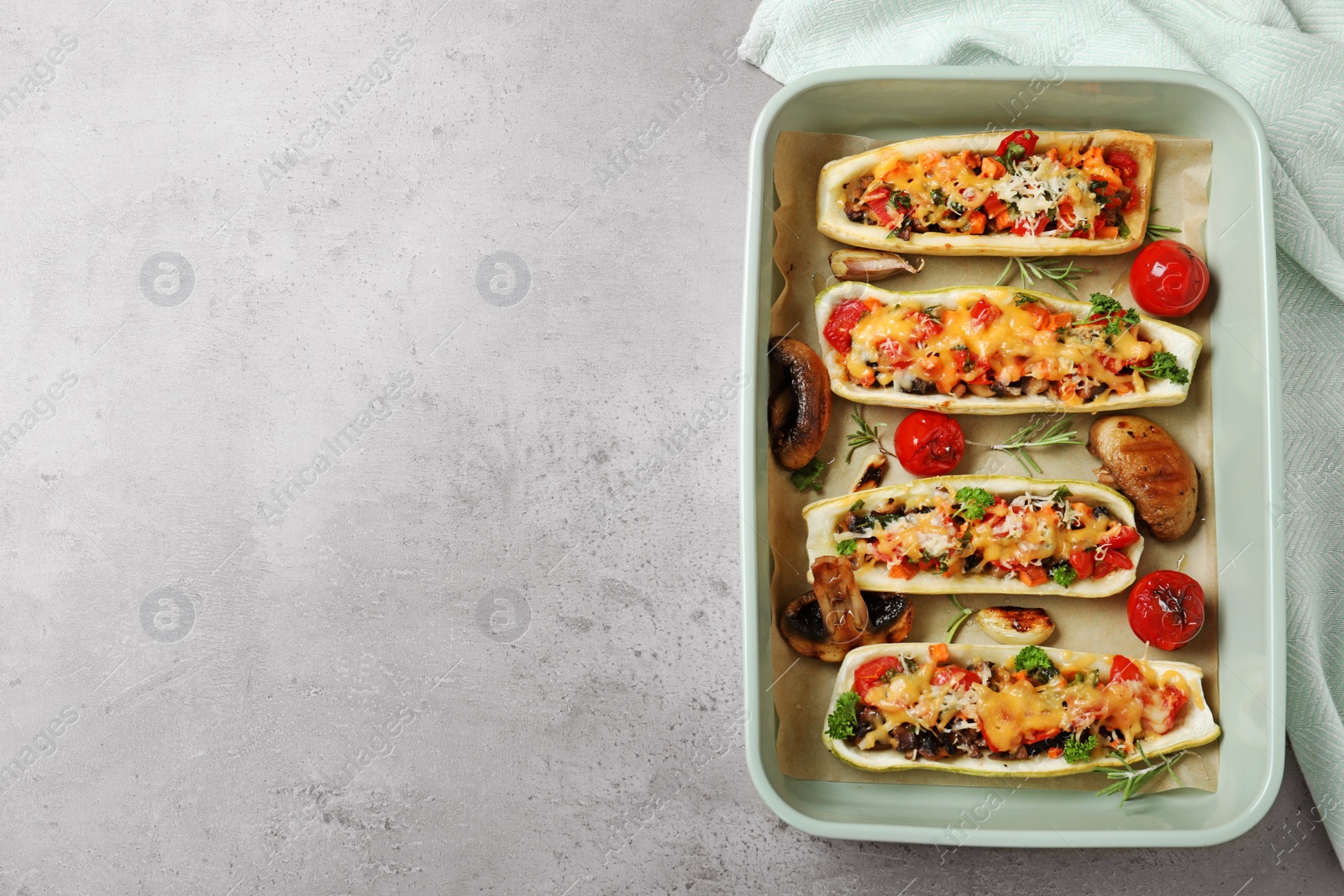 Photo of Flat lay composition with delicious stuffed zucchini on light grey table. Space for text