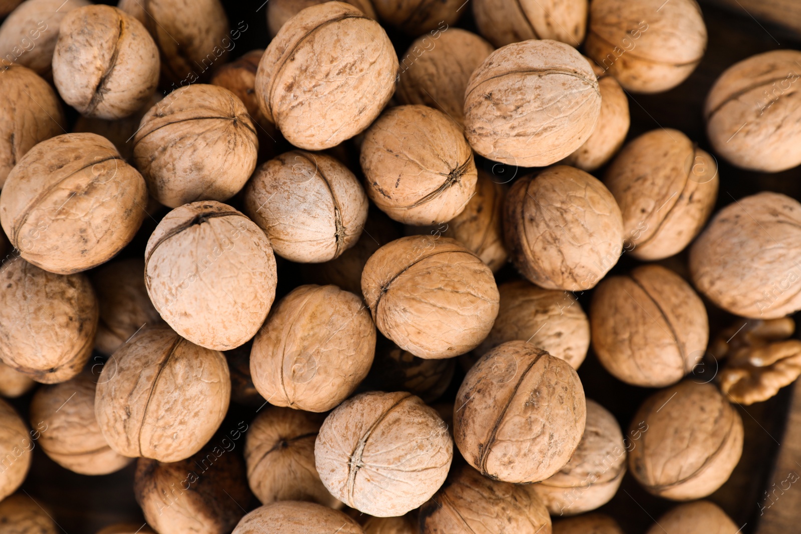 Photo of Many tasty walnuts as background, top view