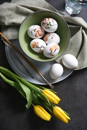 Photo of Flat lay composition with painted Easter eggs on dark table