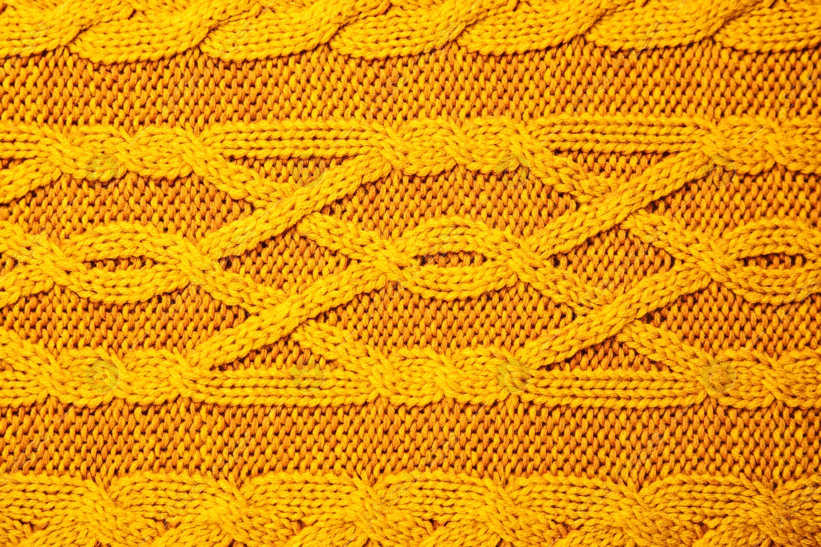 Photo of Soft orange knitted plaid as background, top view
