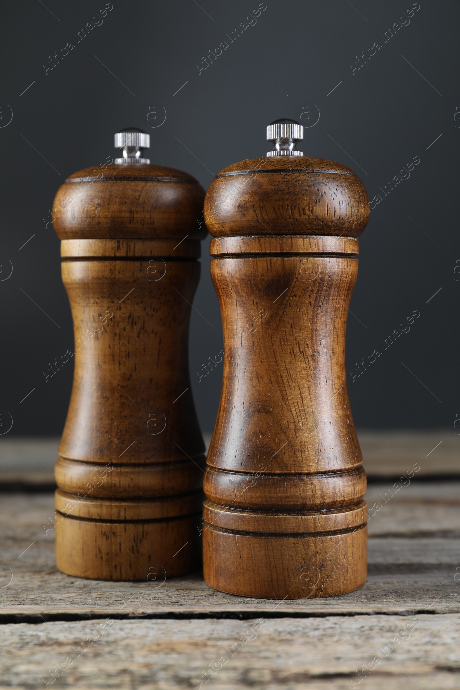 Photo of Salt and pepper shakers on wooden table, closeup