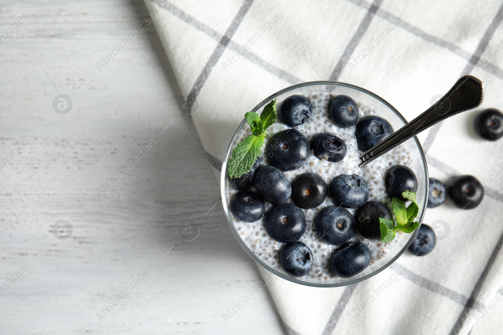 Photo of Tasty chia seed pudding with blueberries in dessert bowl on table, top view. Space for text