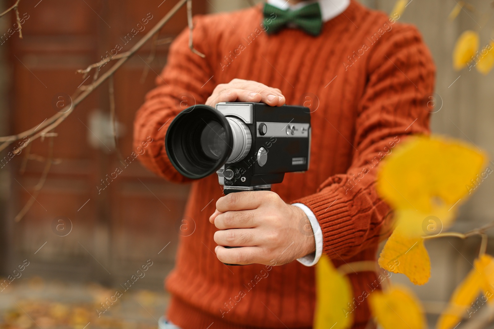 Photo of Young man with vintage video camera outdoors, closeup