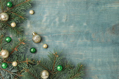 Photo of Flat lay composition with decorated fir branches on blue wooden background, space for text. Winter holidays