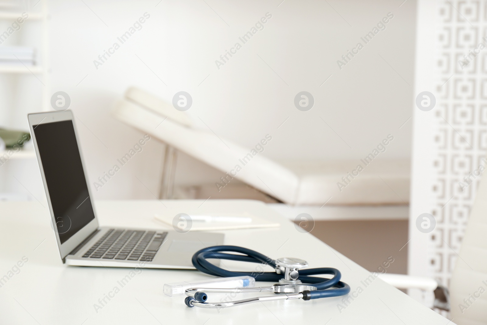 Photo of Doctor's workplace with modern laptop in medical office