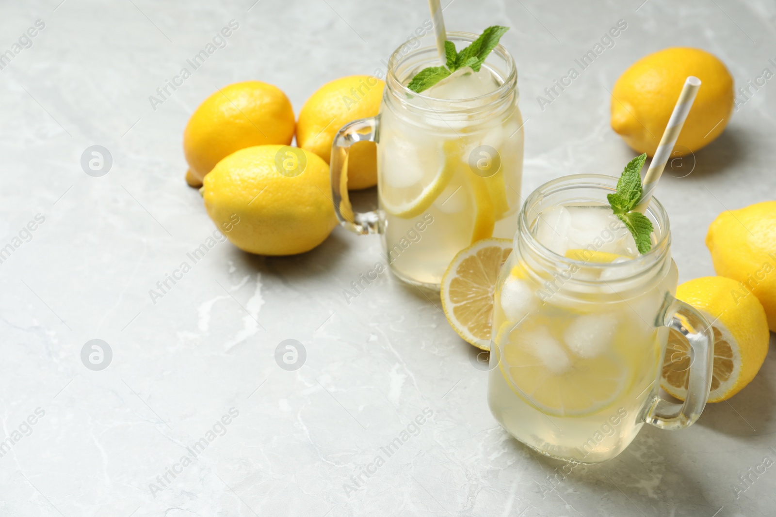 Photo of Natural lemonade with mint and fresh fruits on light grey marble table, space for text. Summer refreshing drink