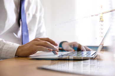 Image of Engineer working with laptop in office and unfinished building, closeup. Double exposure