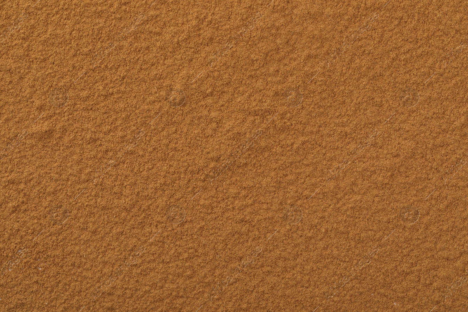 Photo of Dry aromatic cinnamon powder as background, top view