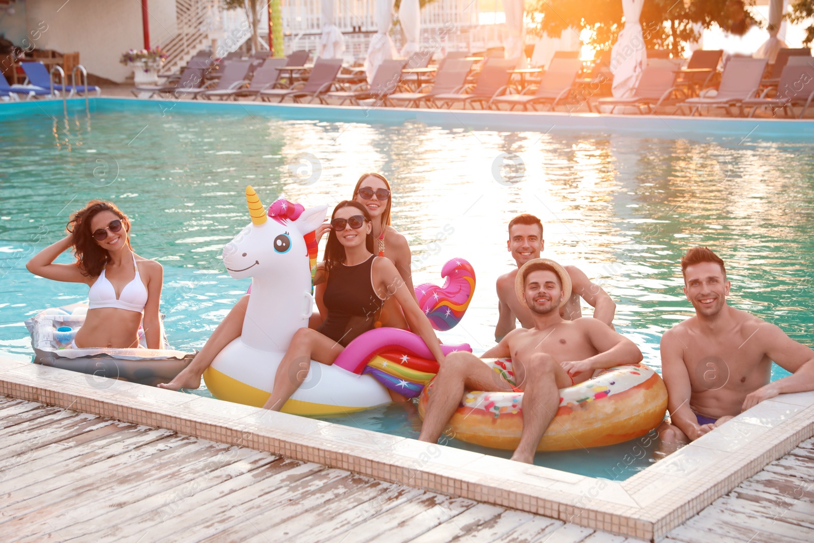 Photo of Happy young friends relaxing in swimming pool