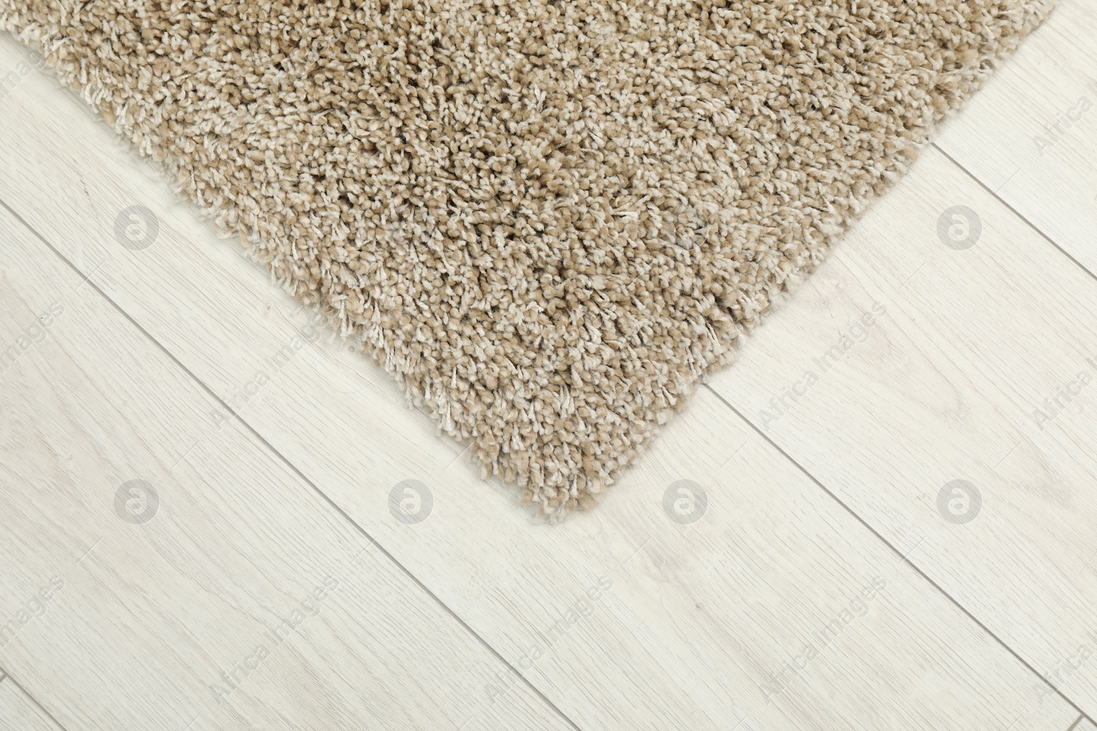 Photo of Soft beige carpet on white laminated floor indoors, top view. Space for text