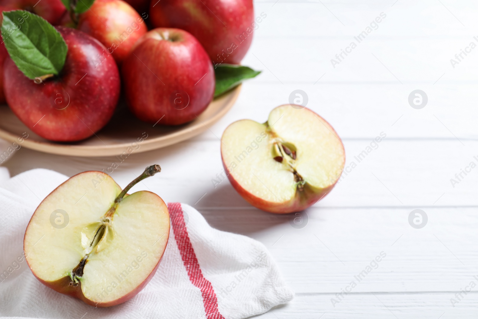 Photo of Juicy red apples on white wooden table, closeup