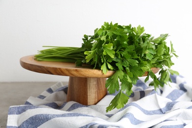 Wooden stand with fresh green parsley on table