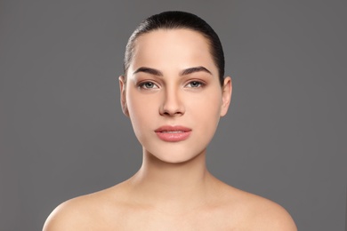 Portrait of young woman with beautiful face and natural makeup on color background