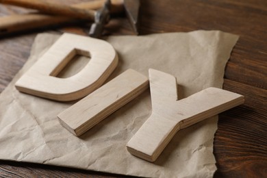 Photo of Abbreviation DIY made of letters on wooden table, closeup