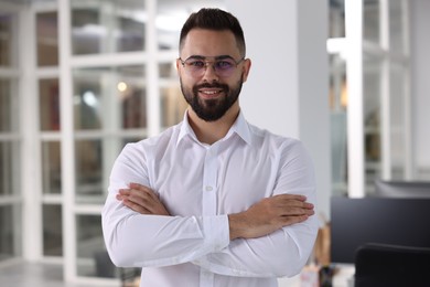 Portrait of smiling man with crossed arms in office. Lawyer, businessman, accountant or manager