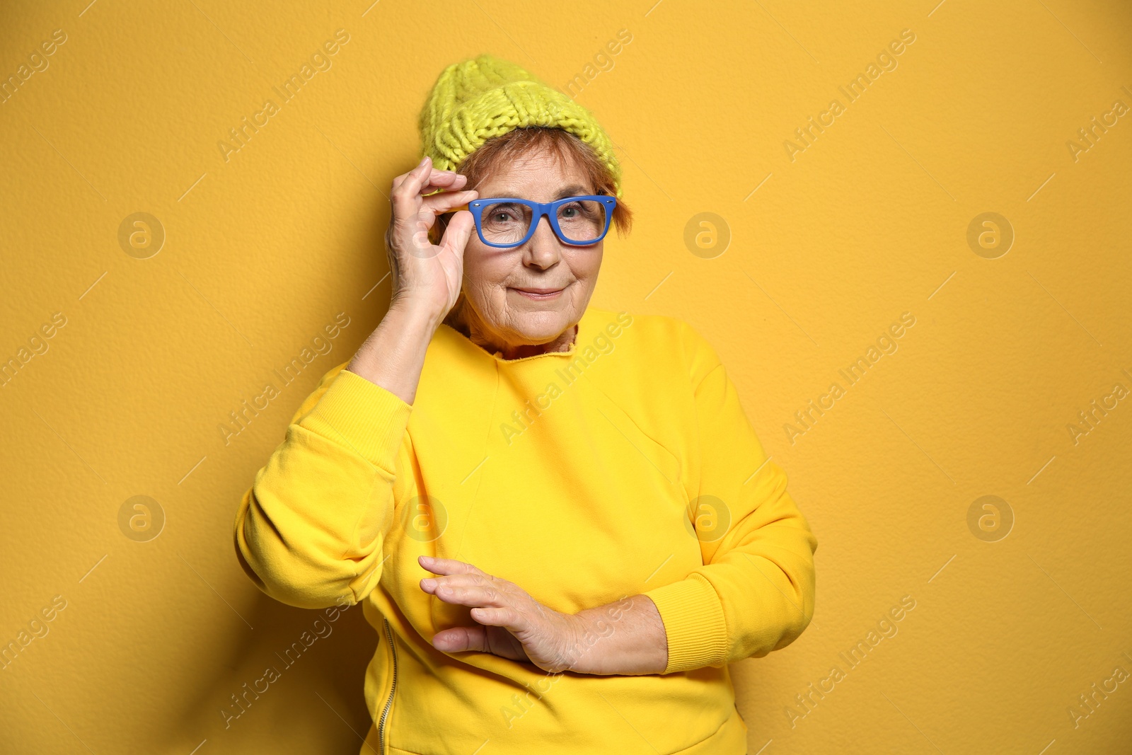 Photo of Portrait of elderly woman in hipster outfit on color background