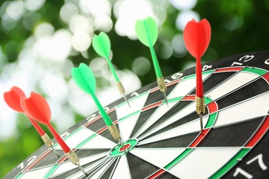 Dart board with color arrows hitting target outdoors
