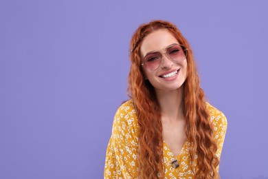 Photo of Stylish young hippie woman in sunglasses on violet background, space for text