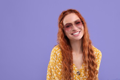 Stylish young hippie woman in sunglasses on violet background, space for text