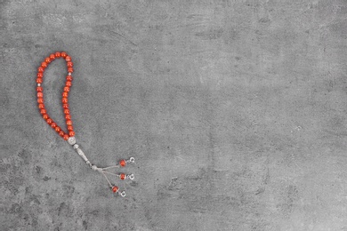 Photo of Muslim prayer beads and space for text on grey background, top view