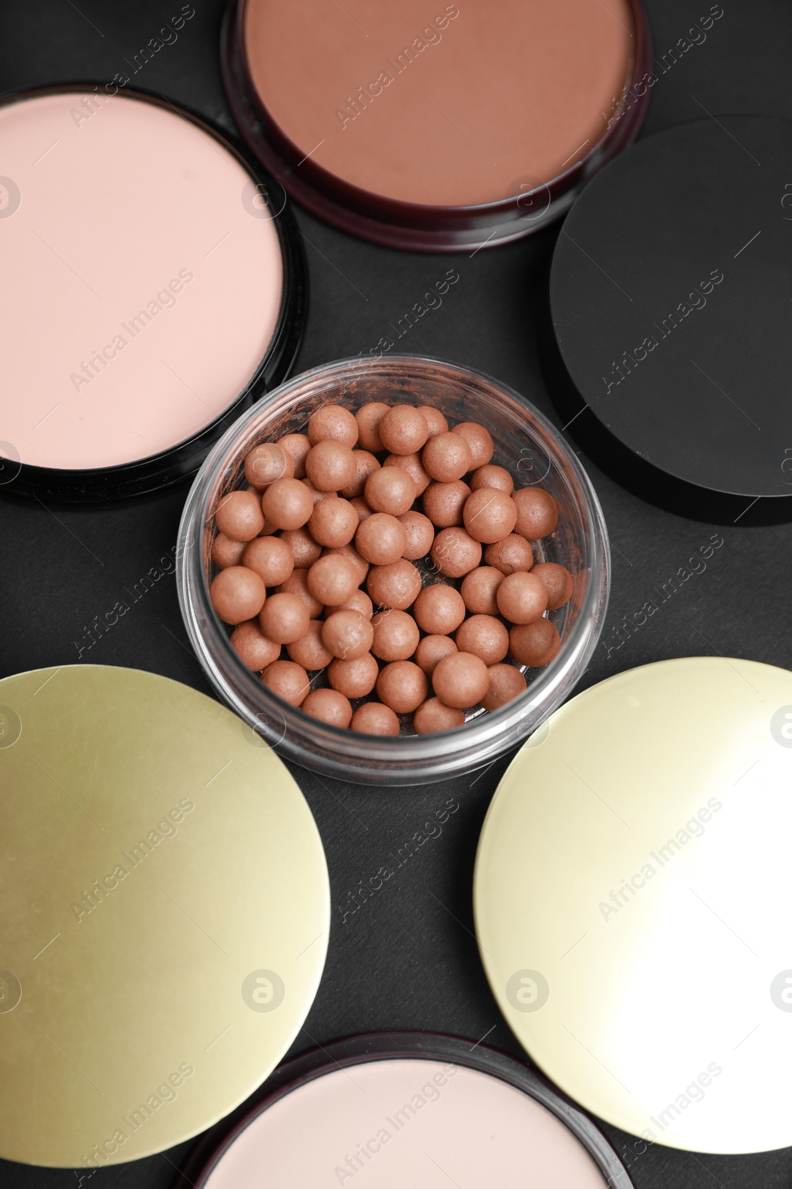 Photo of Different face powders on black table, above view