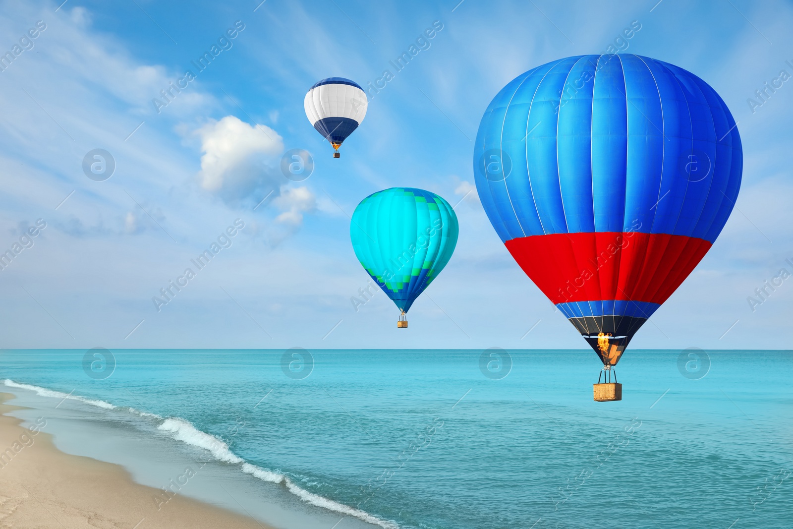 Image of Bright hot air balloons flying over blue sea