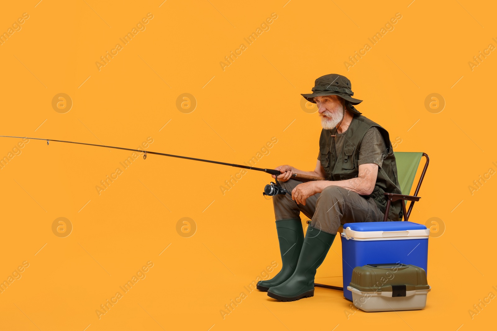 Photo of Fisherman with fishing rod on chair against yellow background