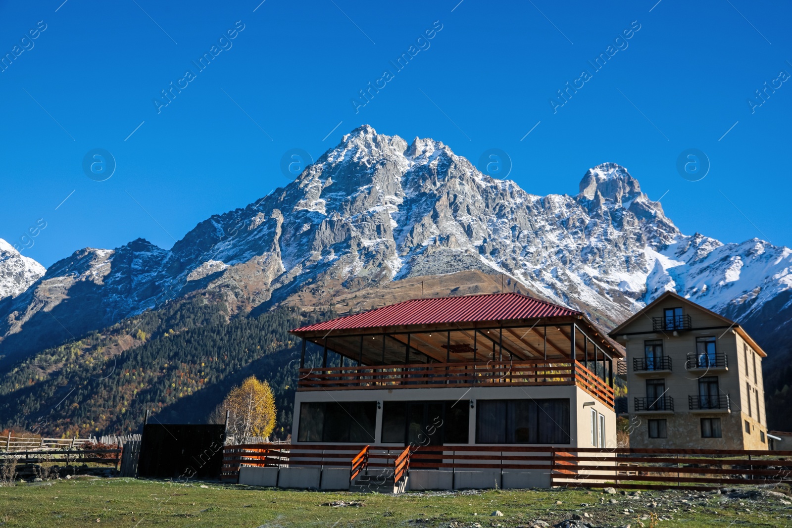 Photo of Picturesque view of village in high mountains under blue sky on sunny day