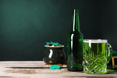 St. Patrick's day party. Green beer, leprechaun hat, pot of gold and decorative clover leaves on wooden table. Space for text