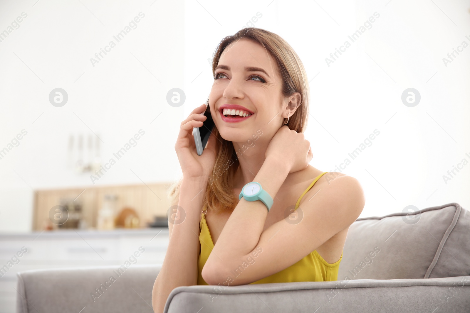 Photo of Young woman talking on phone indoors