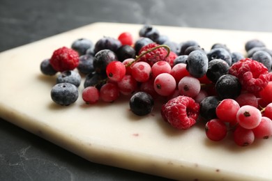 Photo of Mix of tasty frozen berries on black table, closeup