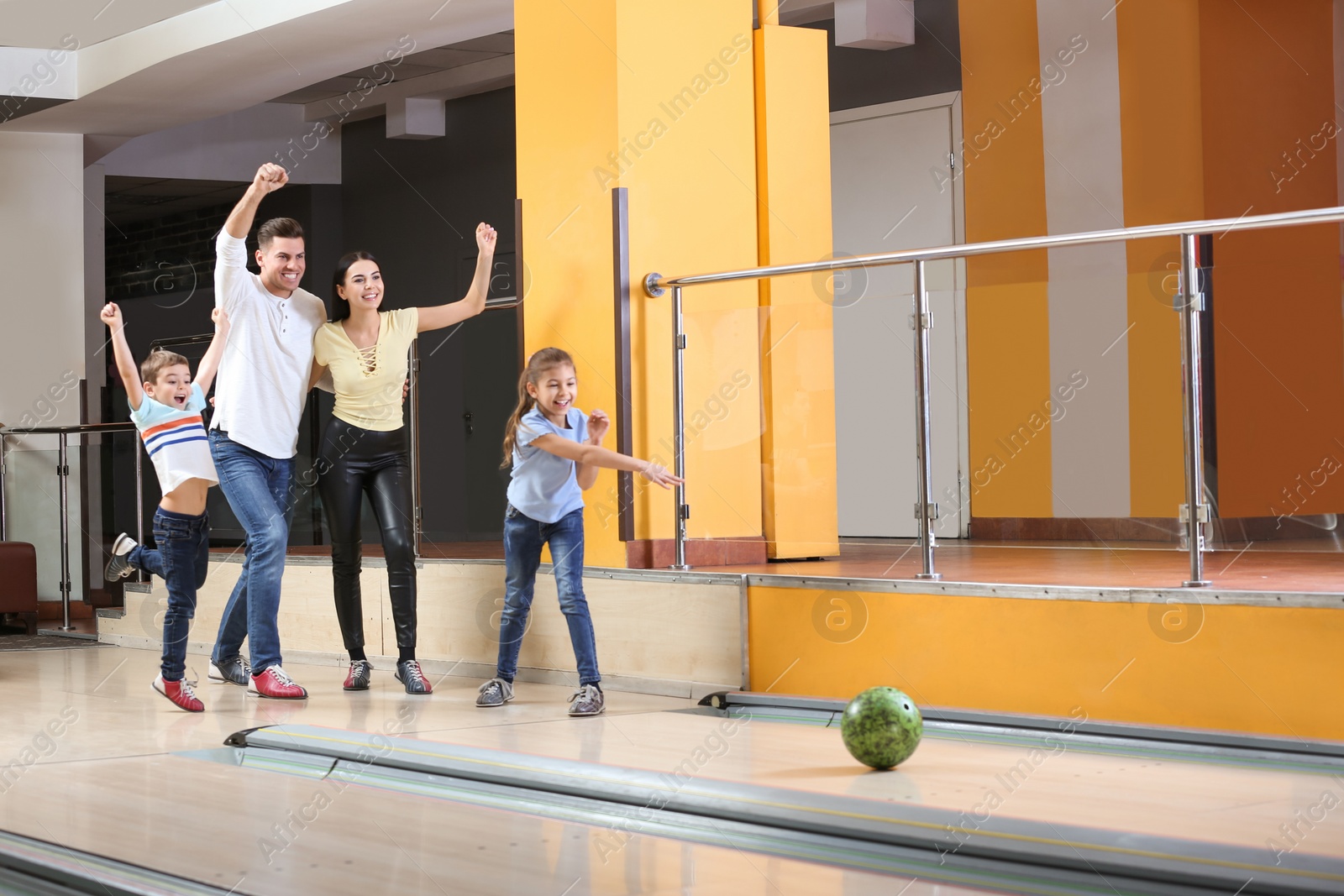 Photo of Happy family spending time together in bowling club