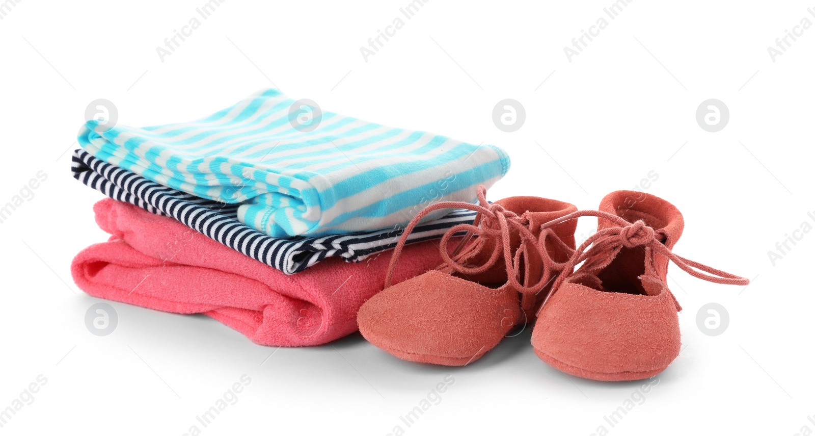 Photo of Stack of child clothes and cute shoes isolated on white