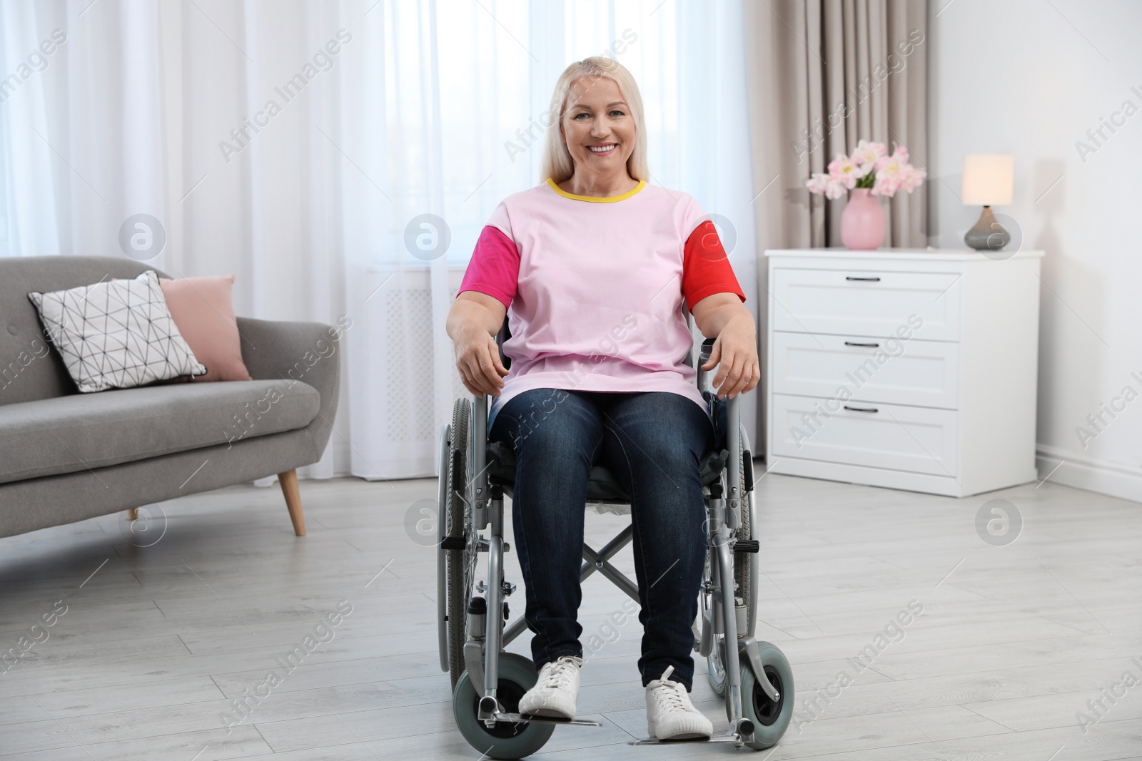 Photo of Mature woman sitting in wheelchair at home