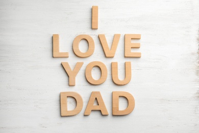 Photo of Words I LOVE YOU DAD with wooden letters on white table, flat lay