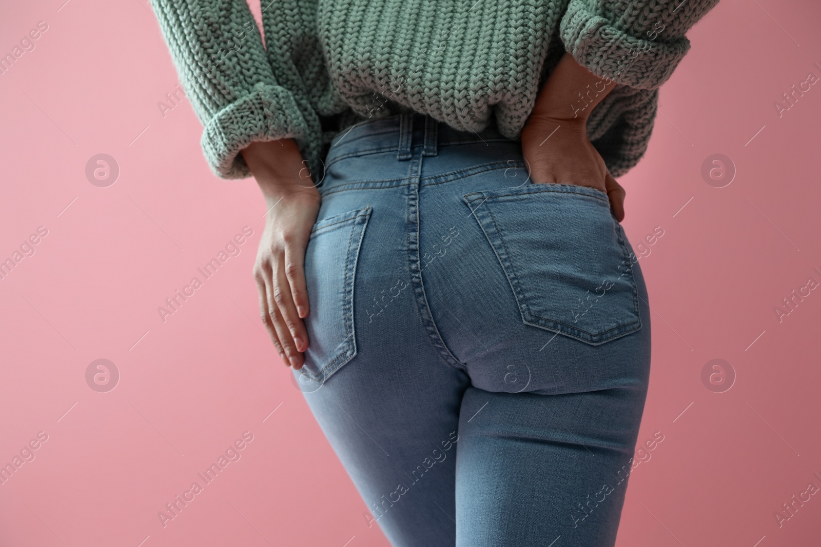 Photo of Woman wearing jeans on pink background, closeup