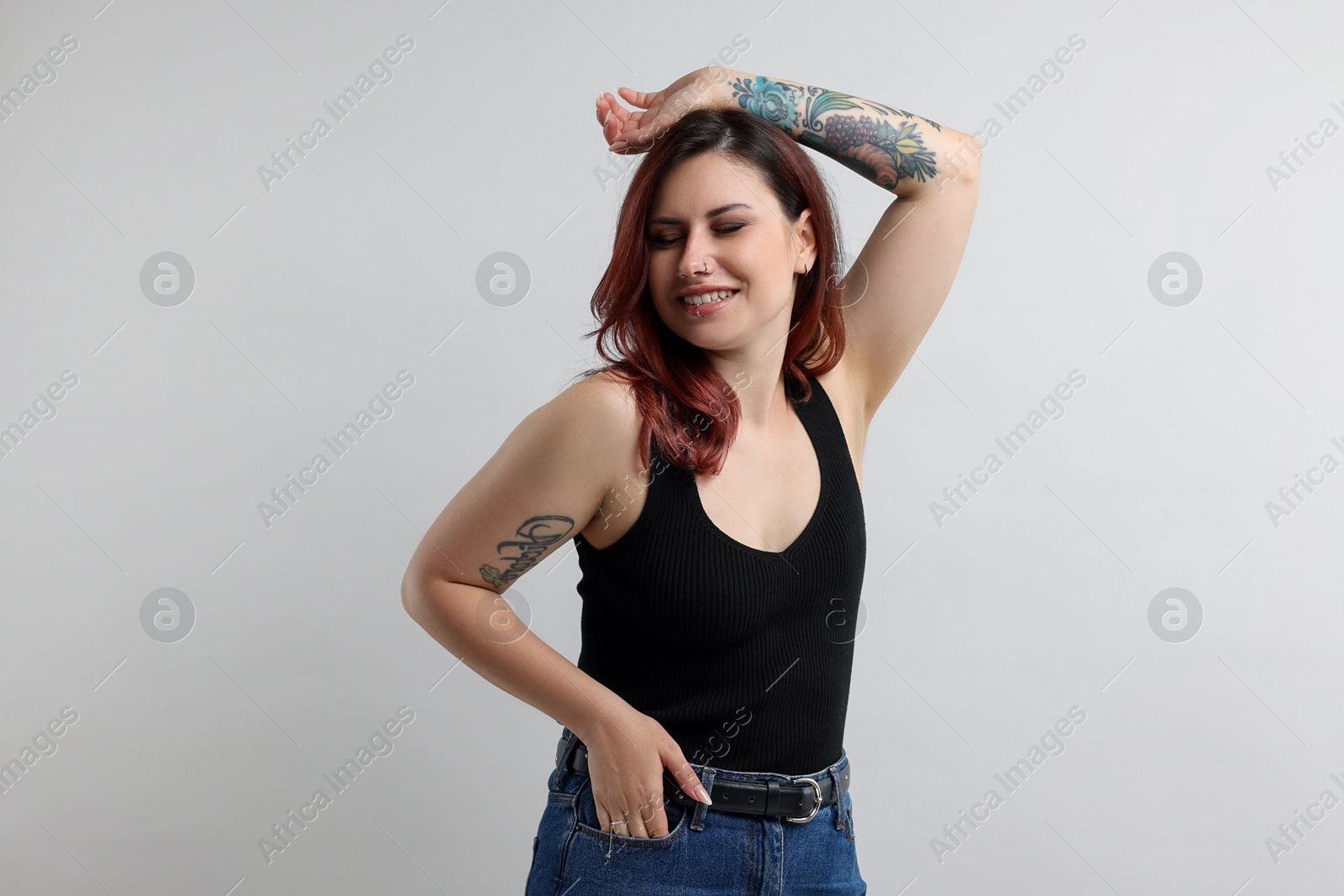 Photo of Portrait of beautiful tattooed woman on gray background