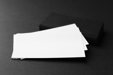 Photo of Blank business cards on black background, closeup. Mockup for design