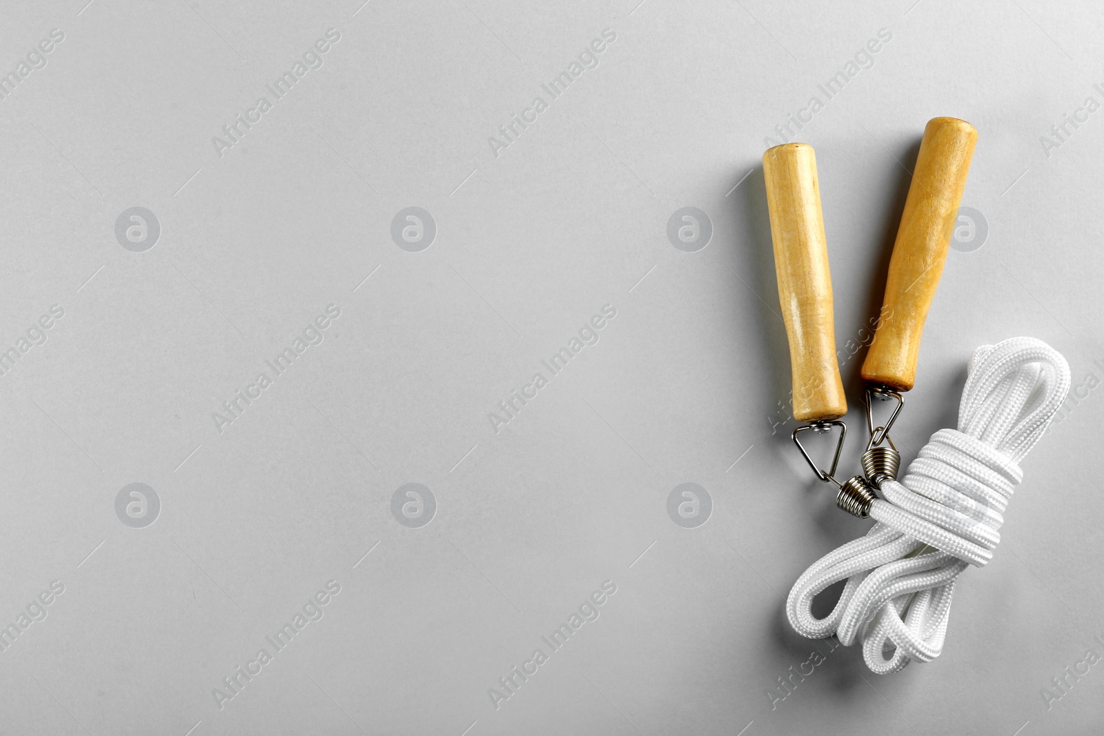 Photo of Skipping rope on light grey background, top view. Space for text