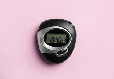 Digital timer on pink background, top view