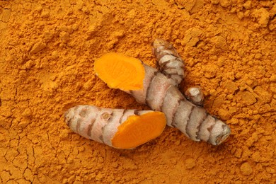 Photo of Cut raw root on aromatic turmeric powder, top view