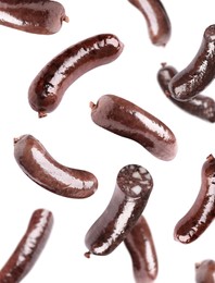 Image of Tasty blood sausages falling on white background 