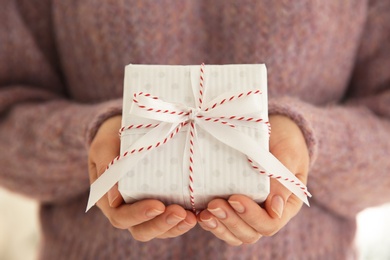 Photo of Woman holding white Christmas gift box, closeup