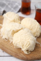 Photo of Eastern sweets. Tasty Iranian pashmak on white wooden table, closeup