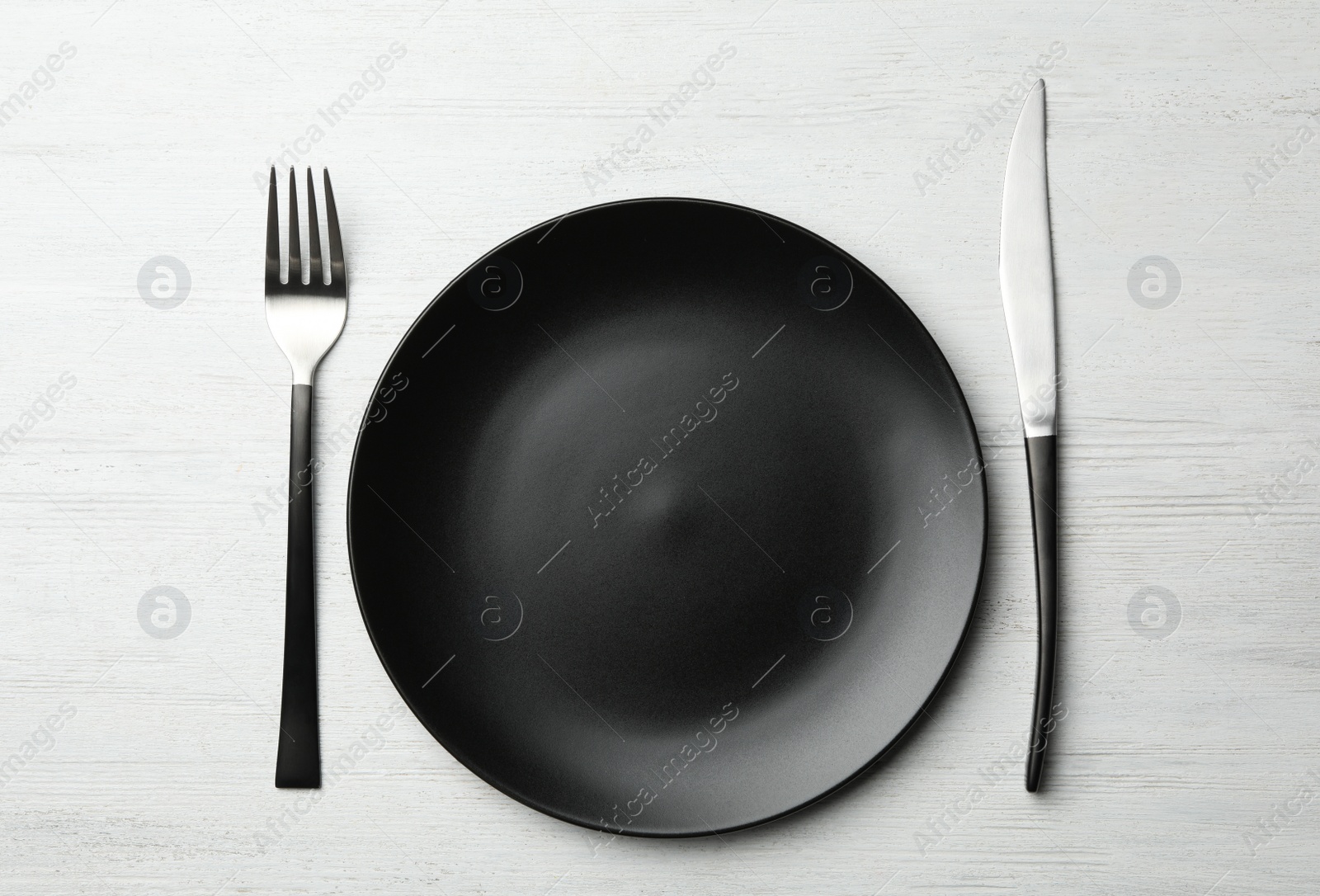 Photo of Stylish ceramic plate and cutlery on white wooden background, flat lay